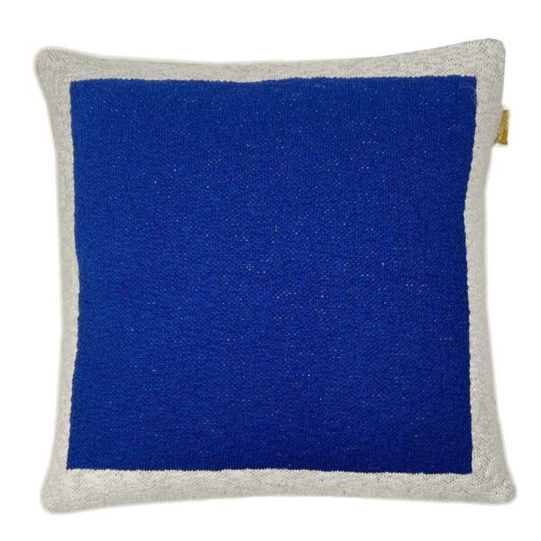 Coussin tricoté Malagoon bleu uni présenté dans un décor intérieur