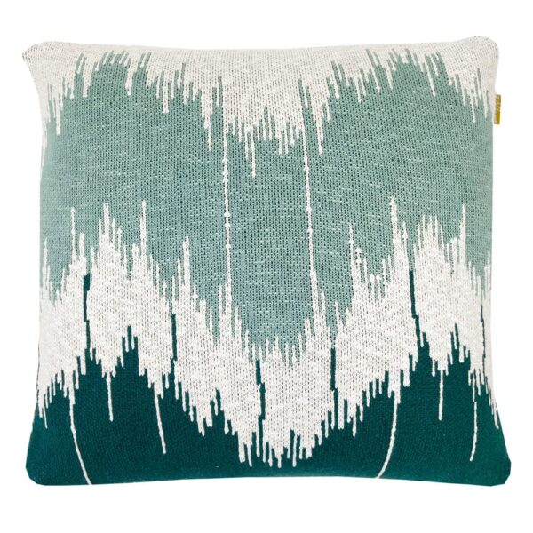 Coussin vague tricoté Malagoon vert, présenté dans un style décoratif en maille